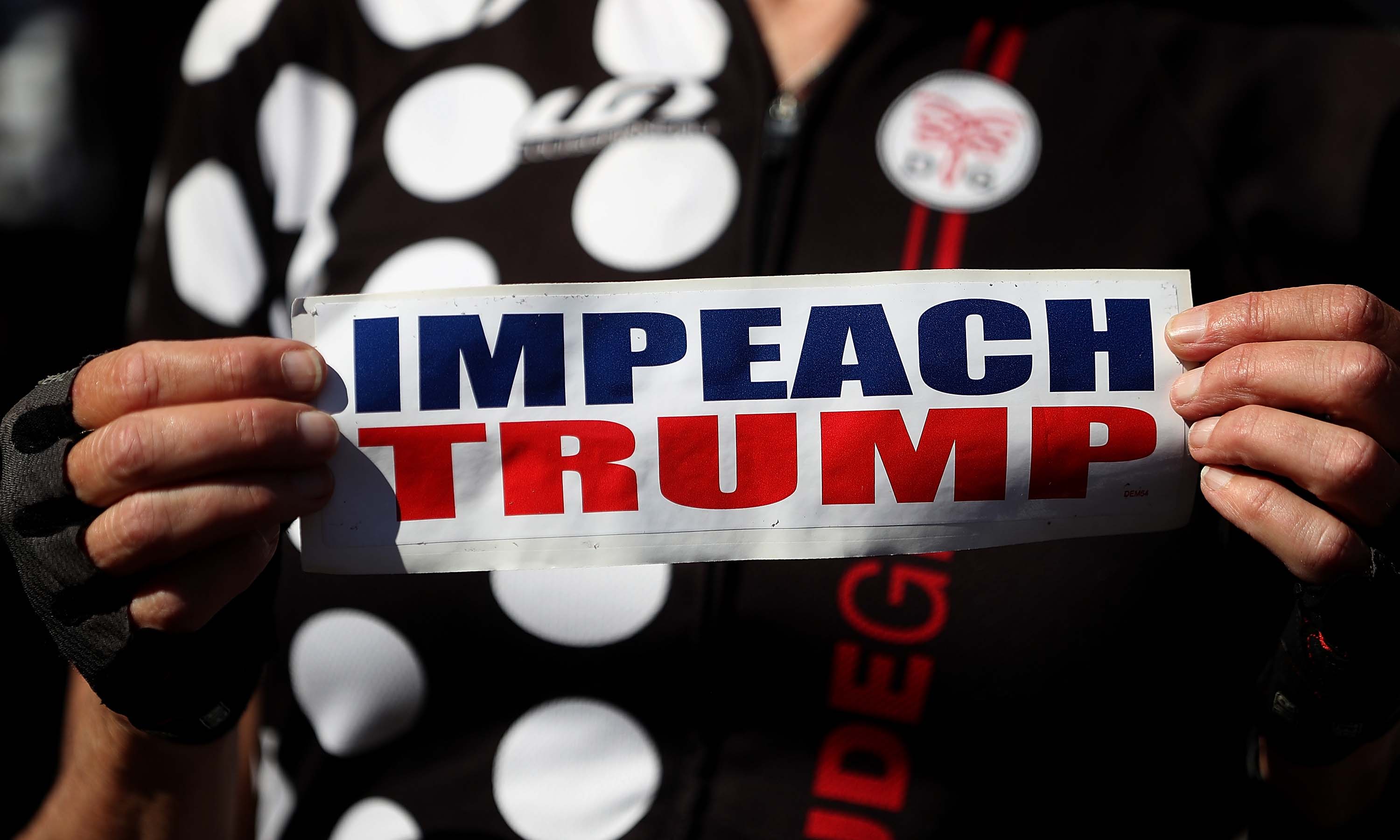 SAN FRANCISCO, CA - OCTOBER 24: An attendee holds a sign calling for the impeachment of U.S. president Donald Trump during a rally and press conference at San Francisco City Hall on October 24, 2017 in San Francisco, California. Billionaire Tom Steyer spoke at a rally and press conference with San Francisco supervisor Sandra Lee Fewer who is the author of a resolution calling on U.S. Congress to initiate impeachment proceedings for U.S. president Donald Trump. Steyer has launched his own $10 million campaign calling on the impeachment of the president. (Photo by Justin Sullivan/Getty Images)