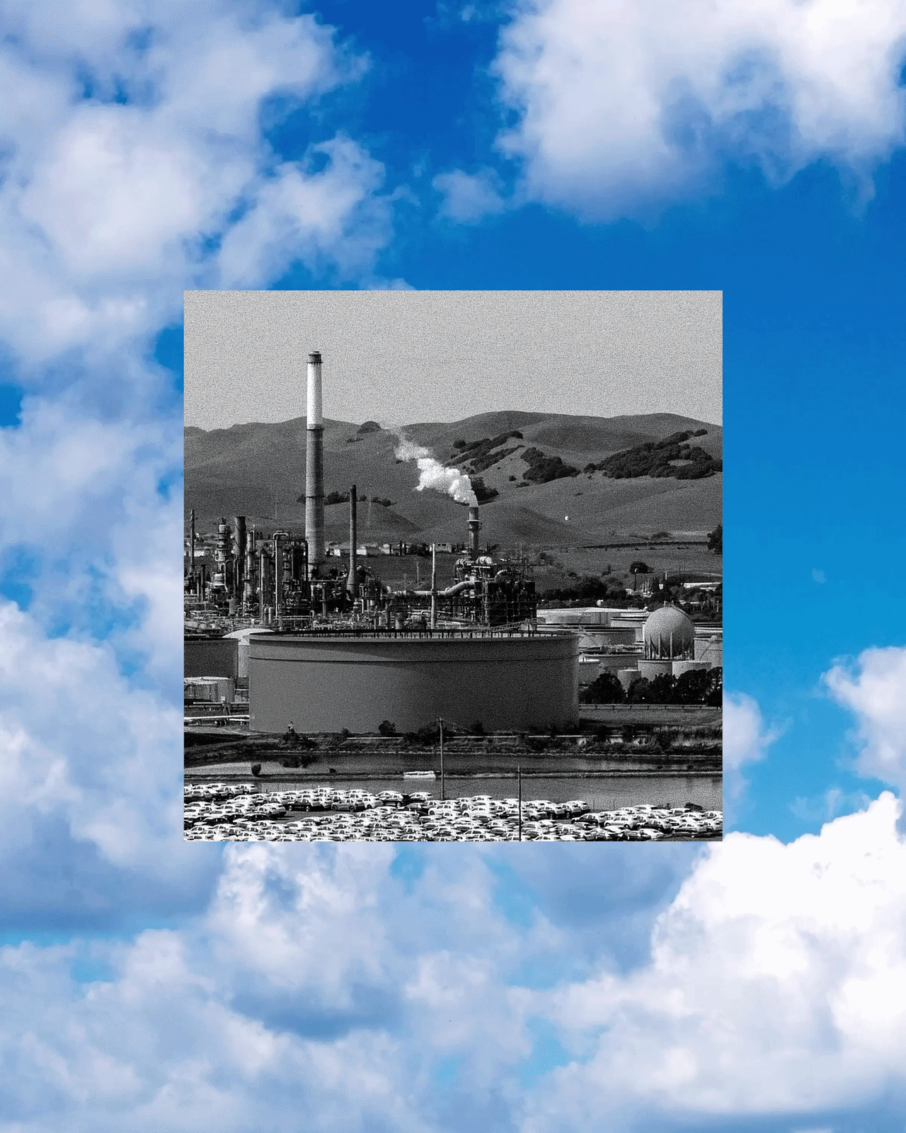 Black-and-white photo of an oil refinery against hills, over animated clouds moving in the background